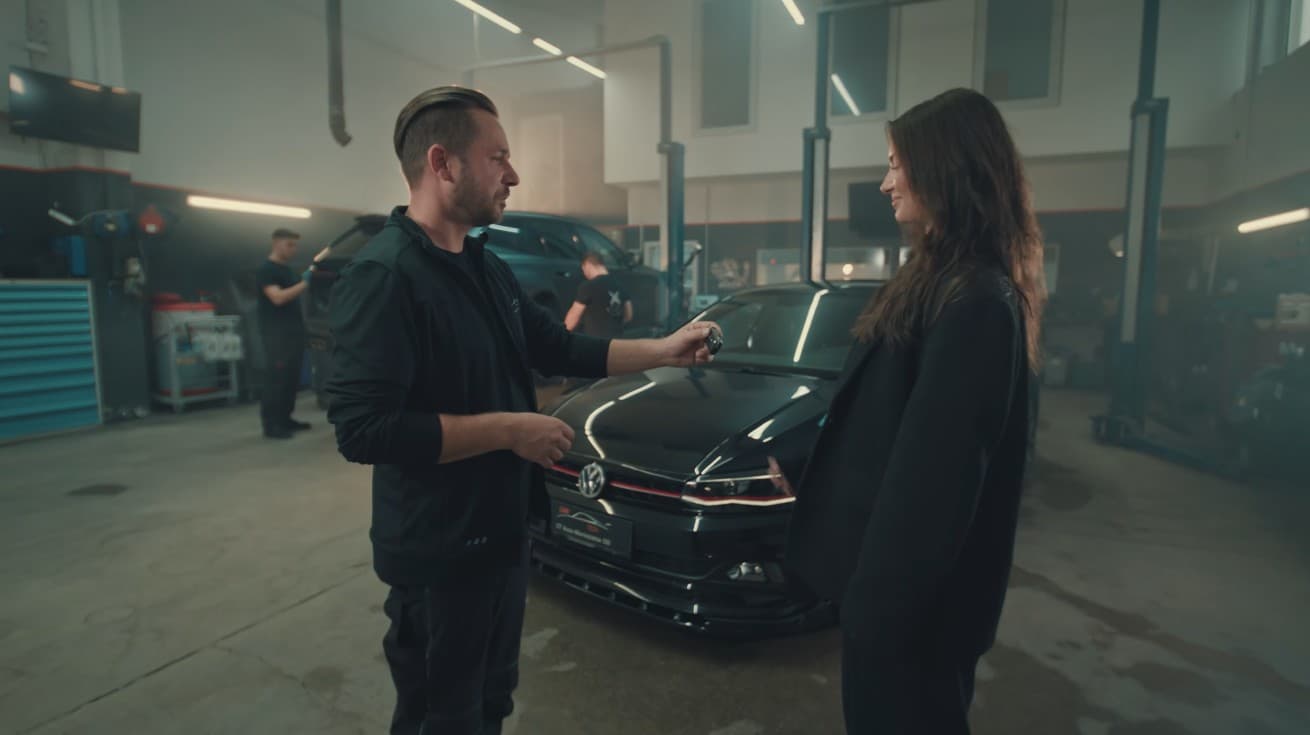 Schlüsselübergabe an eine Kundin in der CarTech-Werkstatt